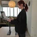 數位遊牧者的移動辦公場景：使用者正操作架高的筆記型電腦，並透過螢幕擴展進行高效率的多工處理，展現安全且專注的數位工作空間。